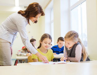 group of school kids writing test in classroom