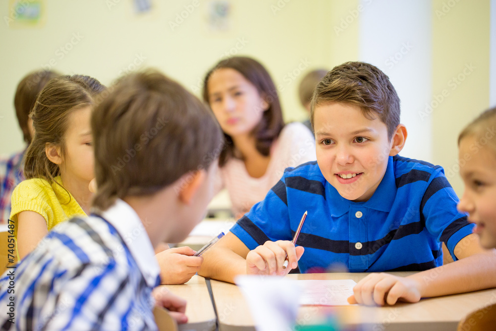 Poster group of school kids writing test in classroom