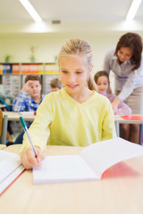 group of school kids writing test in classroom