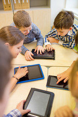group of school kids with tablet pc in classroom