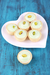 Tartlets with greens and sauce on plate on table
