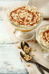 Tasty dessert with oat flakes and honey, on table
