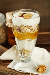 Tasty dessert with oat flakes and honey, on table