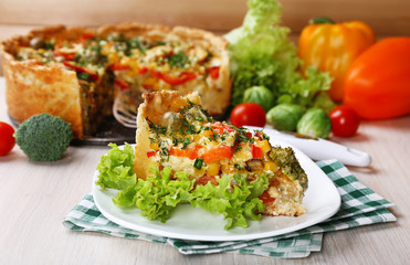 Piece of Vegetable pie with broccoli, peas, tomatoes and cheese