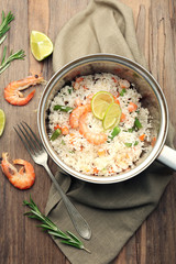 Tasty rice in pan on wooden table