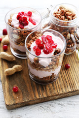 Healthy layered dessert with muesli and berries on table