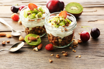 Healthy layered dessert with muesli and fruits on table
