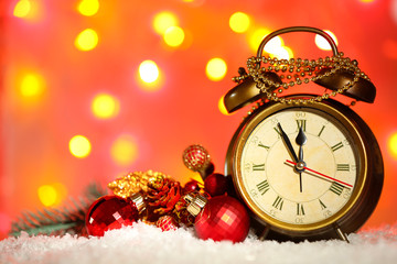 Fototapeta na wymiar Alarm clock with Christmas decorations on bright background