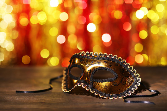 Beautiful carnival mask on table on bright background