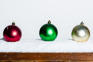 Three Christmas ornaments on a railing