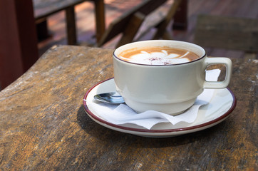 A cup of hot coffee on old wooden