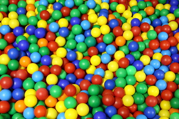 lots of blue green red yellow colored spheres into a pool of bal