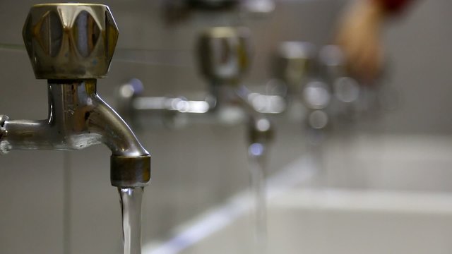 man closes many faucets to prevent water wastage