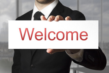 businessman holding sign welcome
