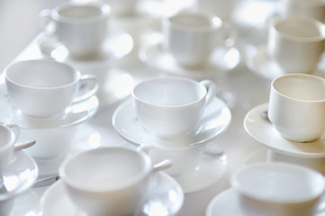 Many rows of pure white cups and saucers