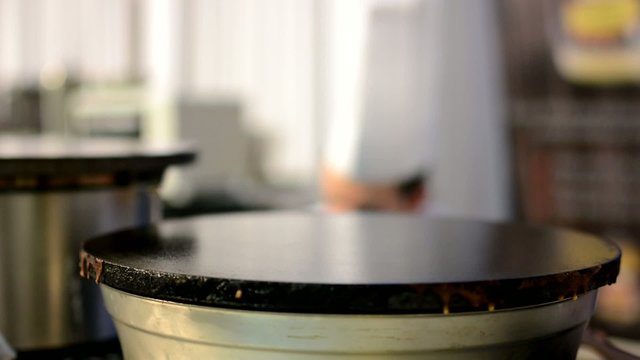 empty warming surface (pan) for pancake - chef in background