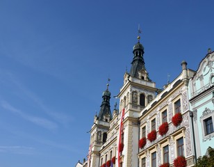 Ornamented building with flags and flowers on windows