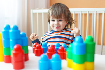 toddler boy (2 years) playing plastic blocks at home