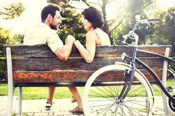 Couple in love sitting together on a bench with bikes