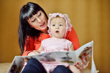 mother reading to baby girl