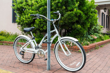 Fototapeta na wymiar White Bicycle Locked to a Sign Post