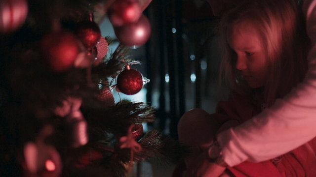 Little girl with dad decorate the Christmas tree for the New