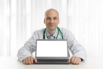 handsome doktor sitting at a desk with laptop