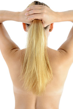 Blonde Frau mit langen Haaren richtet Frisur