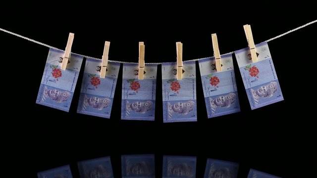 Dirty Malaysia Ringgit money hanging from a clothesline