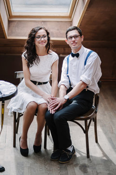 Portrait of young couple in classic clothes posing modest.