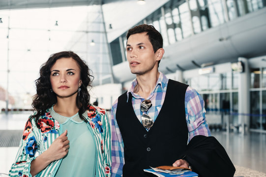 Couple in casual clothes style posing at the airport.