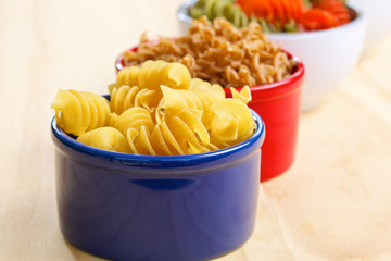 Variety of uncooked italian pasta on wooden table