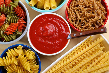 Variety of uncooked italian pasta on wooden table