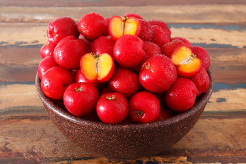 Red acerola - malpighia glabra, tropical fruit  in bowl on table