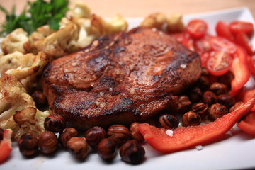 grilled meat cooked with nuts and vegetables serving