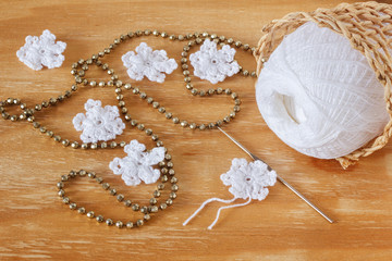 White crochet snowflakes for Christmas decoration on wooden tabl