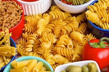 Variety of uncooked italian pasta on wooden table