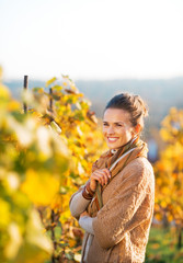 Portrait of happy young woman standing in autumn vineyard