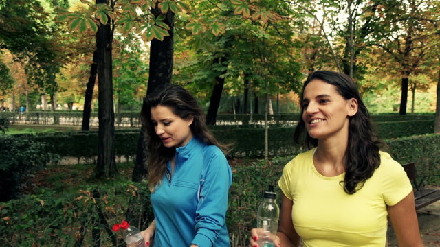 Sporty friends talking and walking in the autumn park