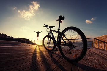 silhouette of sportsman and mountain bike at the sunset