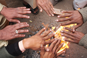 Men warm hands over the fire in India, Agra - 74091656