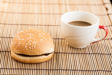 hamburgers and cup of black coffee on wooden board.
