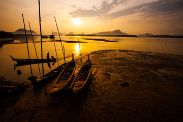 Silhouette of fisherman and traditional thai boats at Sam chong