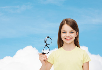 smiling cute little girl holding black eyeglasses