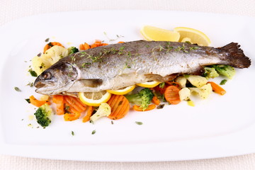 Grilled whole trout with vegetables and lemon