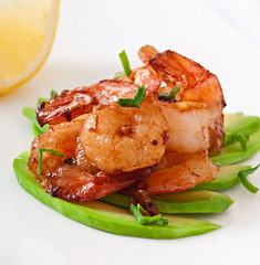 Shrimp sauteed with garlic and soy sauce on a cushion of avocado