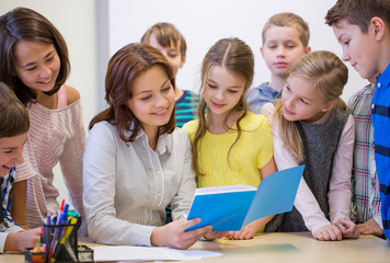 group of school kids with teacher in classroom