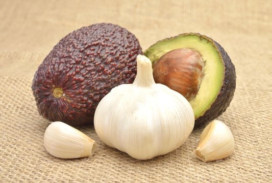 Avocado and garlic on old canvas background