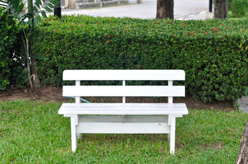 Single white bench in garden for relaxing.