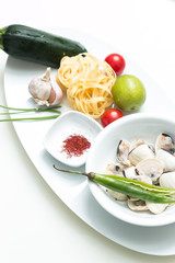 Garlic cloves with uncooked pasta, saffron, scallops, lime,  zuc